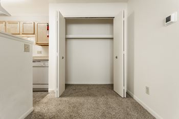 a bedroom with an open closet and a kitchen at Polo Run Apartments, Greenwood, IN